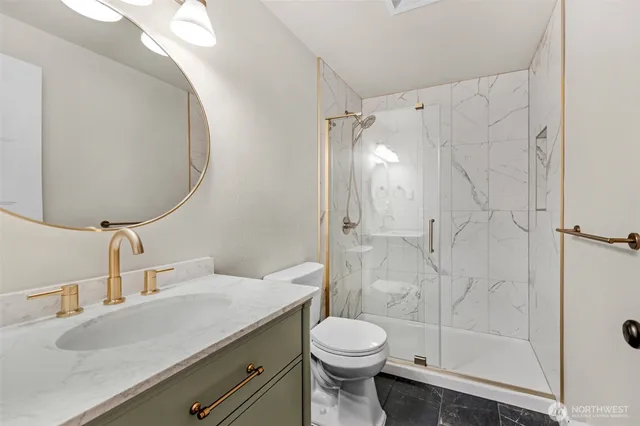 a bathroom with a sink a toilet and shower