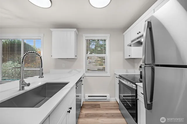a kitchen with stainless steel appliances granite countertop a sink stove and refrigerator