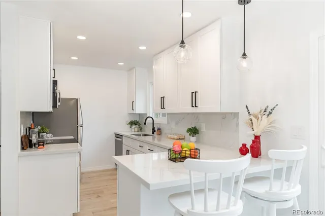 a kitchen with stainless steel appliances granite countertop a sink refrigerator and cabinets