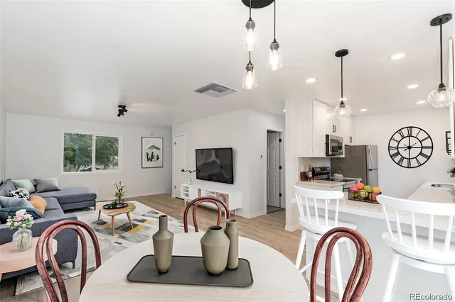 a work room with furniture a clock and a view of kitchen