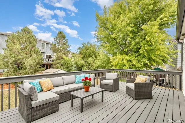 a view of roof deck with seating space and trees