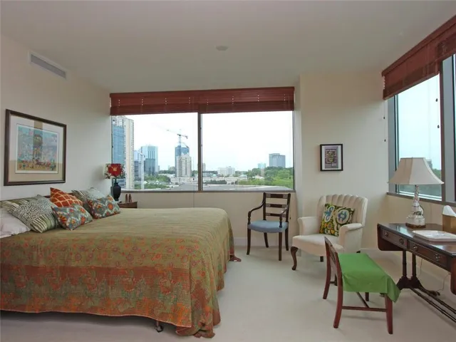 a bedroom with bed and a large window