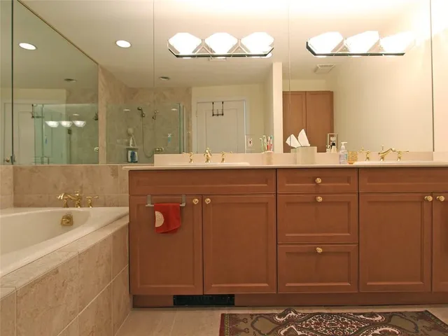 a bathroom with a sink a large mirror and a bathtub