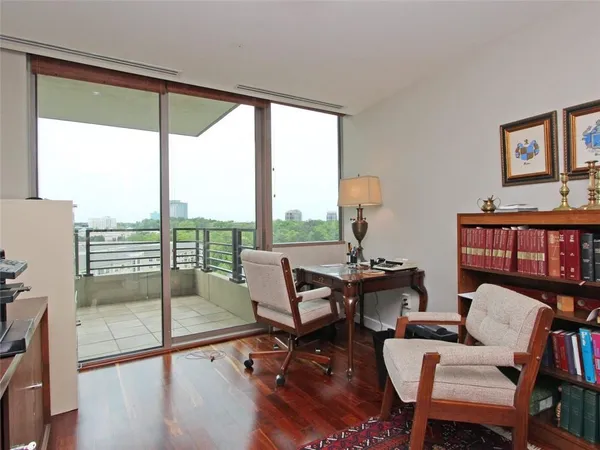 a living room with furniture a rug and a floor to ceiling window
