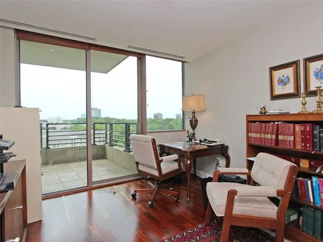 a living room with furniture a rug and a floor to ceiling window
