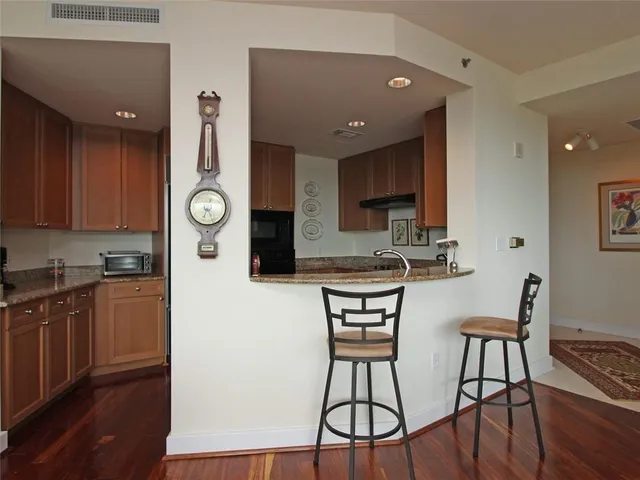 a kitchen with stainless steel appliances kitchen island a refrigerator and wooden cabinets