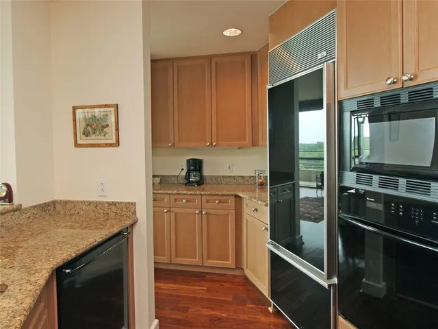 a kitchen with granite countertop cabinets stainless steel appliances and a counter space