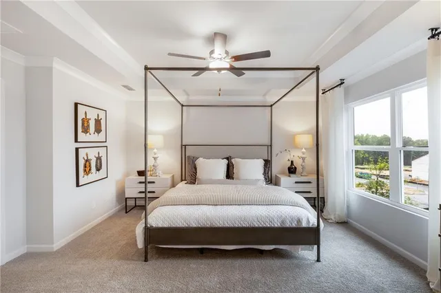 a bedroom with a large bed and a chandelier fan