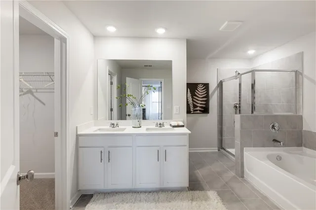 a large bathroom with a double vanity sink a large mirror and a bathtub