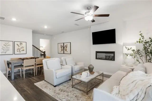 a living room with furniture a flat screen tv and a fireplace
