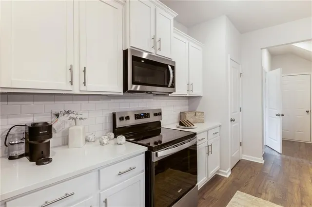 a kitchen with appliances a sink and cabinets