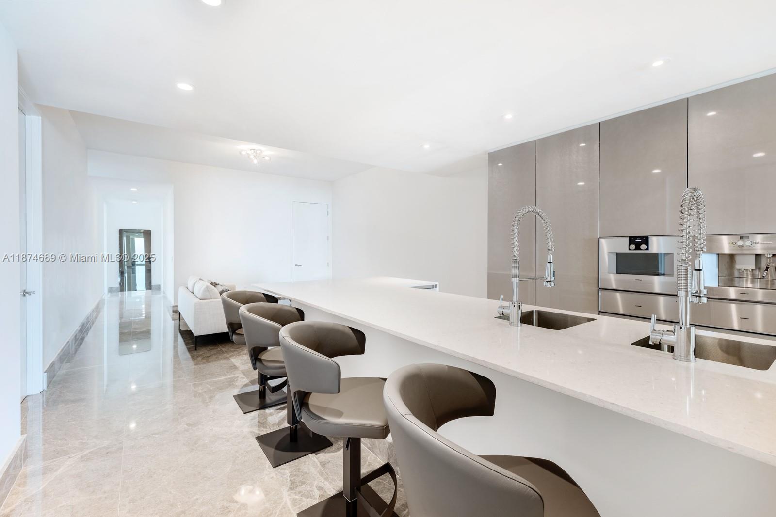 9349 Collins Avenue, Unit 403 Surfside, FL 33154 - Photo 3 of 9 a kitchen with a sink a couch and chairs