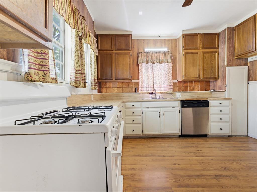 601 South Miller Street Decatur, TX 76234 - Photo 26 of 36 a kitchen with stainless steel appliances white cabinets and a window