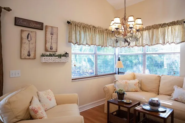 a living room with furniture a chandelier and a dining table