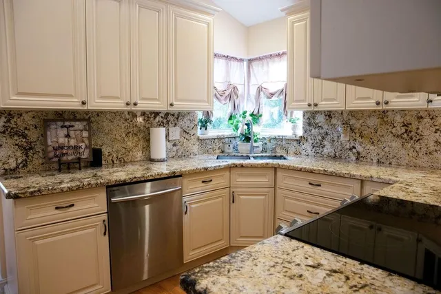 a kitchen with stainless steel appliances kitchen island granite countertop a sink a stove and cabinets