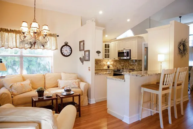 a living room with furniture a fireplace and kitchen view