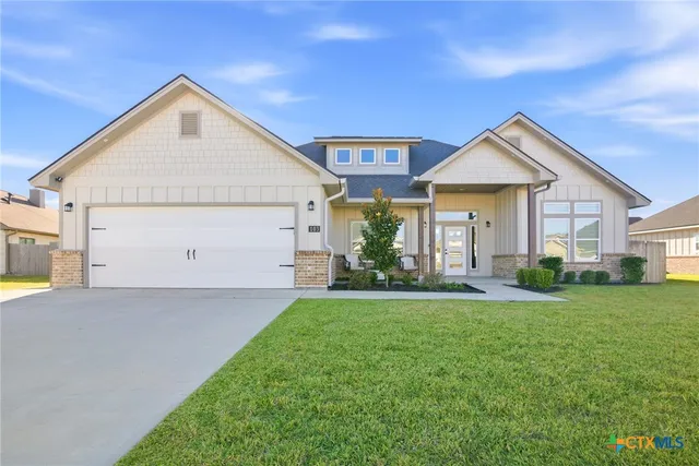 a view of a house with a yard and garage