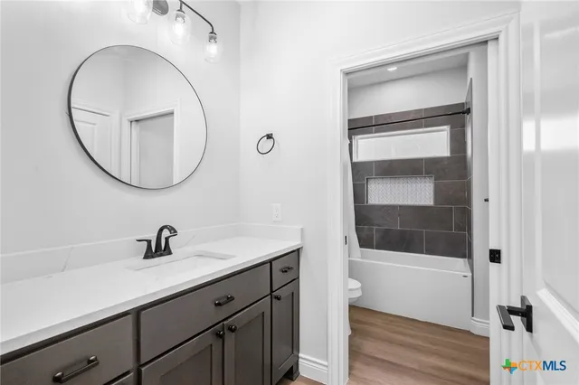 a bathroom with a sink a bathtub and a mirror