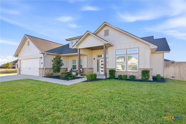 a view of a house with a yard and sitting area