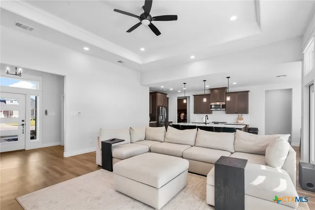 a living room with furniture and a view of kitchen