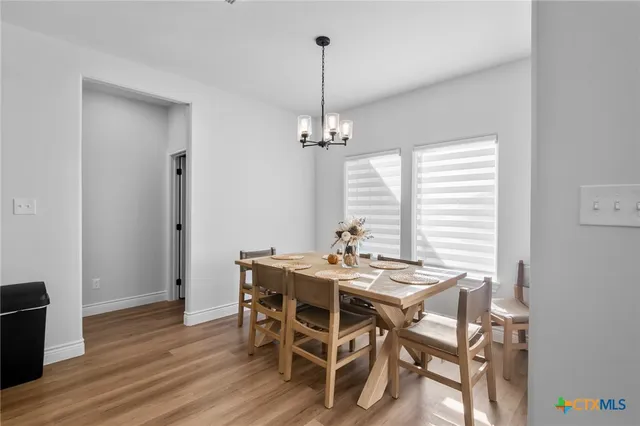 a view of a dining room with furniture wooden floor and chandelier