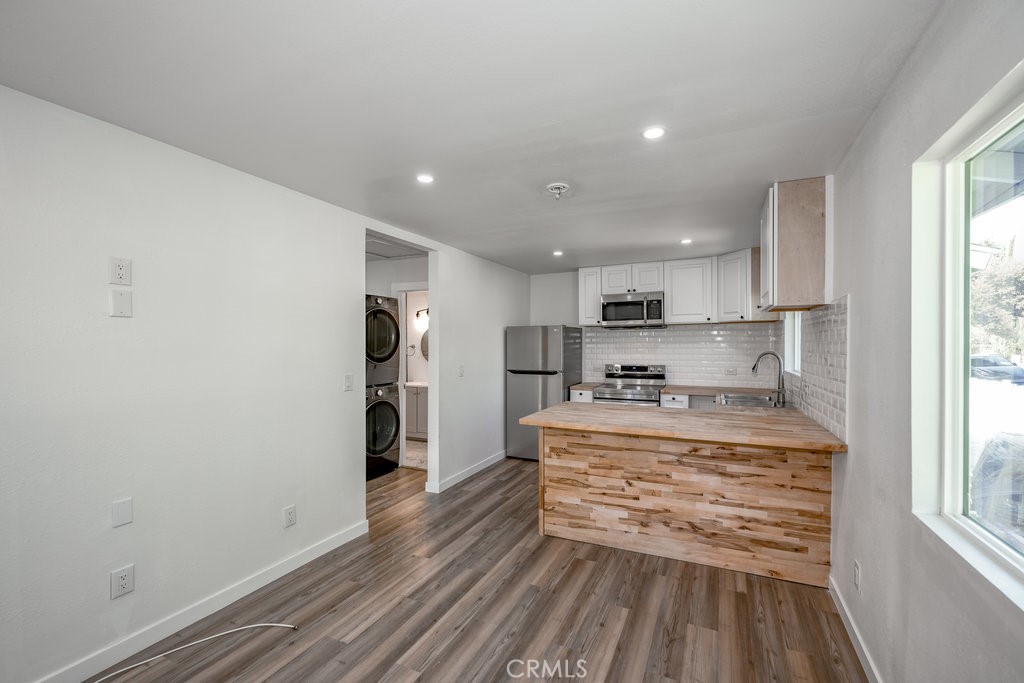 a kitchen with kitchen island a stove a refrigerator and a window