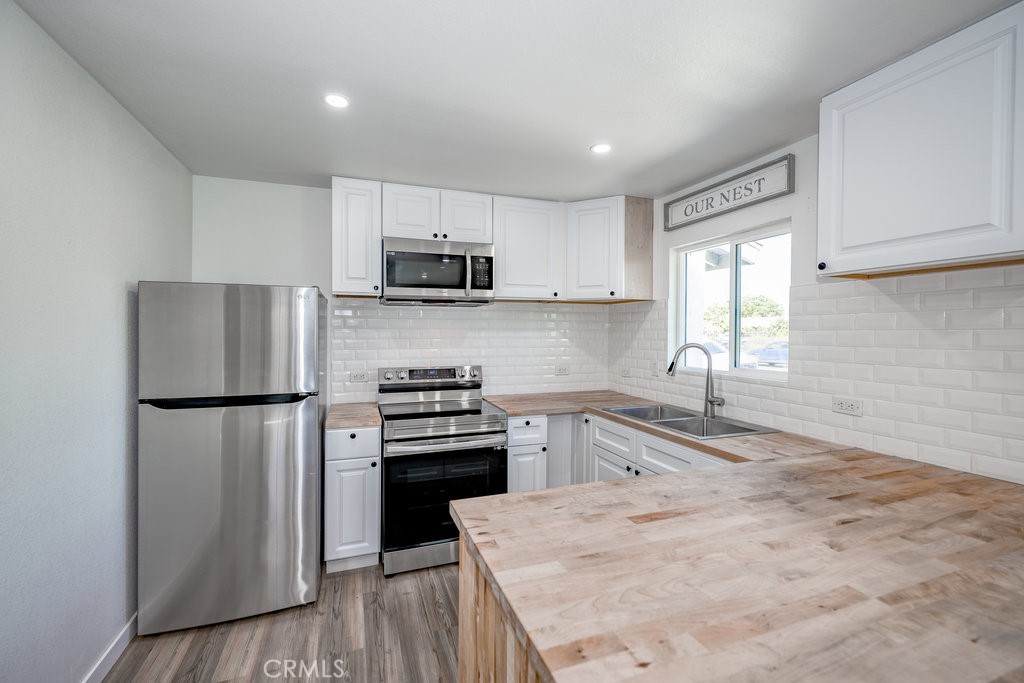 1069 Erringer Road, Unit 1 Simi Valley, CA 93065 - Photo 2 of 8 a kitchen with kitchen island white cabinets a refrigerator and a sink