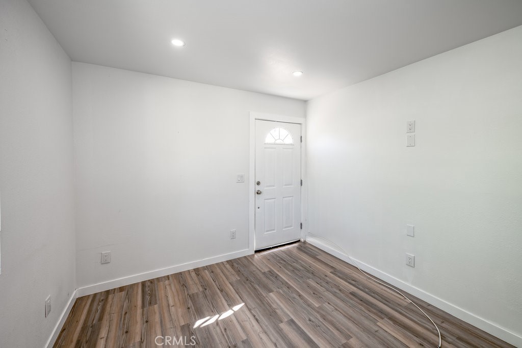 1069 Erringer Road, Unit 1 Simi Valley, CA 93065 - Photo 3 of 8 a view of a room with wooden floor and white walls