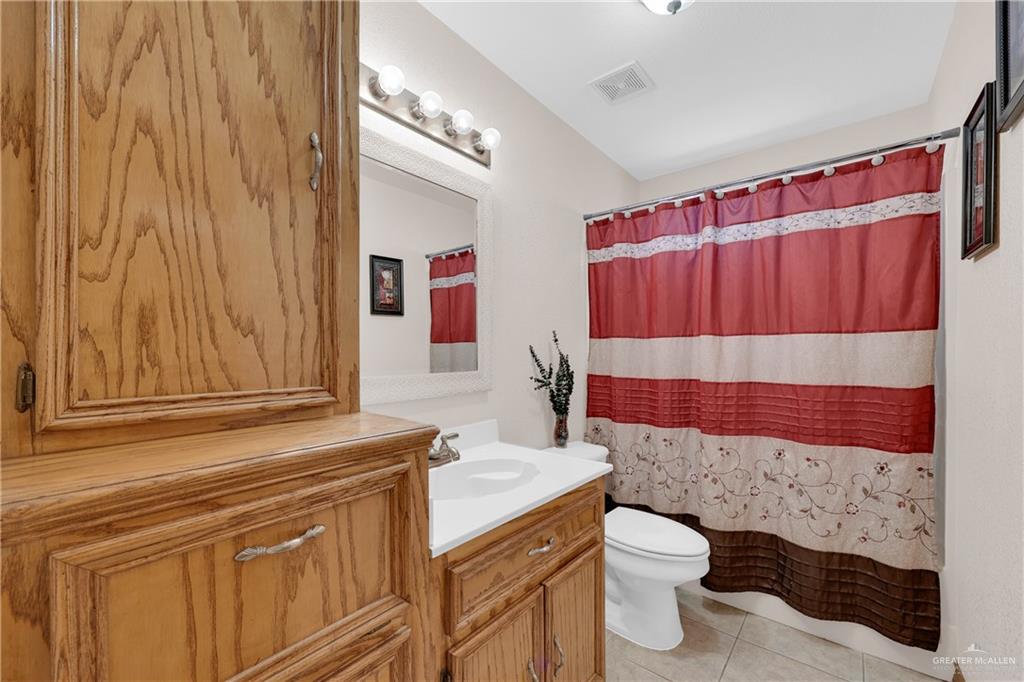 1607 West Main Street Rio Grande City, TX 78582 - Photo 5 of 31 a bathroom with a sink a toilet and shower curtain
