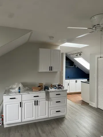a kitchen with white cabinets and white appliances