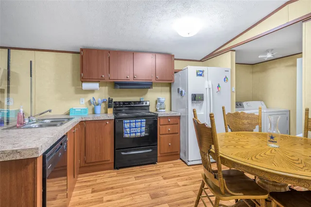 a kitchen with stainless steel appliances granite countertop a refrigerator sink and cabinets