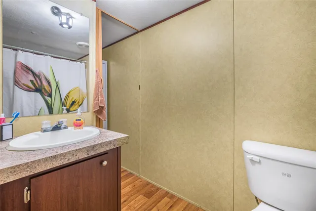 a bathroom with a granite countertop sink a toilet and a mirror