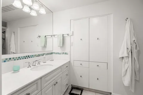 a bathroom with a double vanity sink mirror and shower