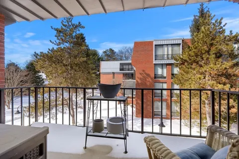 a balcony with wooden floor and outdoor seating