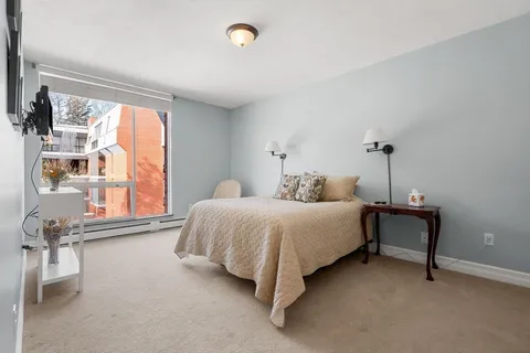 a bedroom with a bed chair and a window