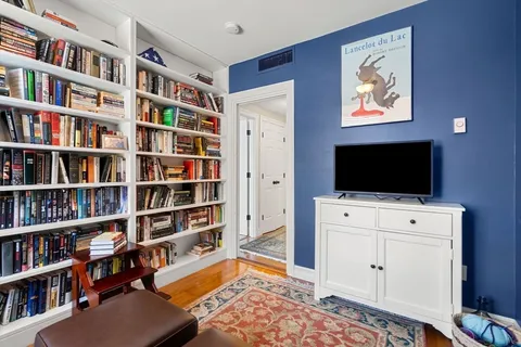 a room with a flat screen tv and a book shelf