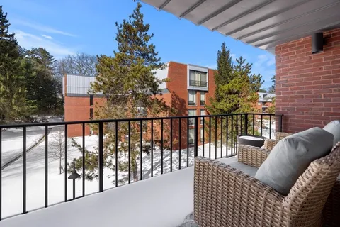 a view of a balcony with wooden floor and outdoor seating