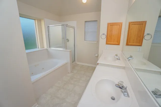 a bathroom with a tub sink and mirror