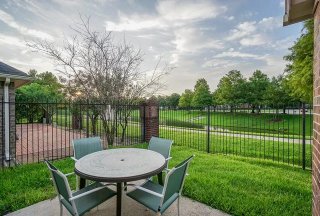 a view of a house with a backyard table and chairs