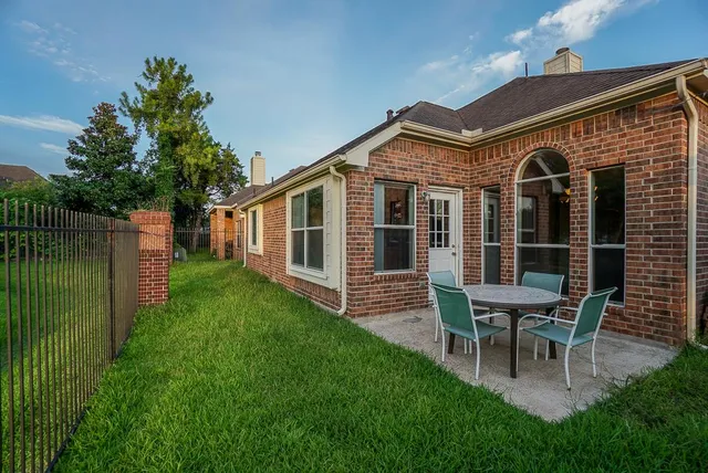 a view of a house with backyard and sitting area