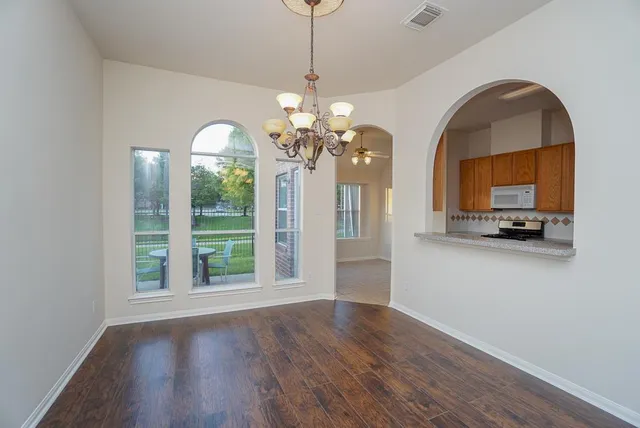 a view of a livingroom with a fireplace wooden floor windows and a chandelier