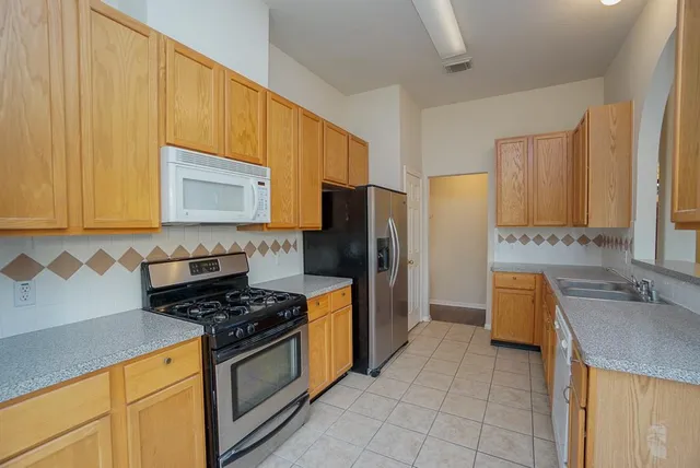 a kitchen with a sink stove and refrigerator