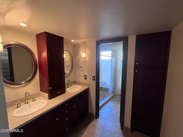 a en suite bathroom with a double vanity sink and a mirror