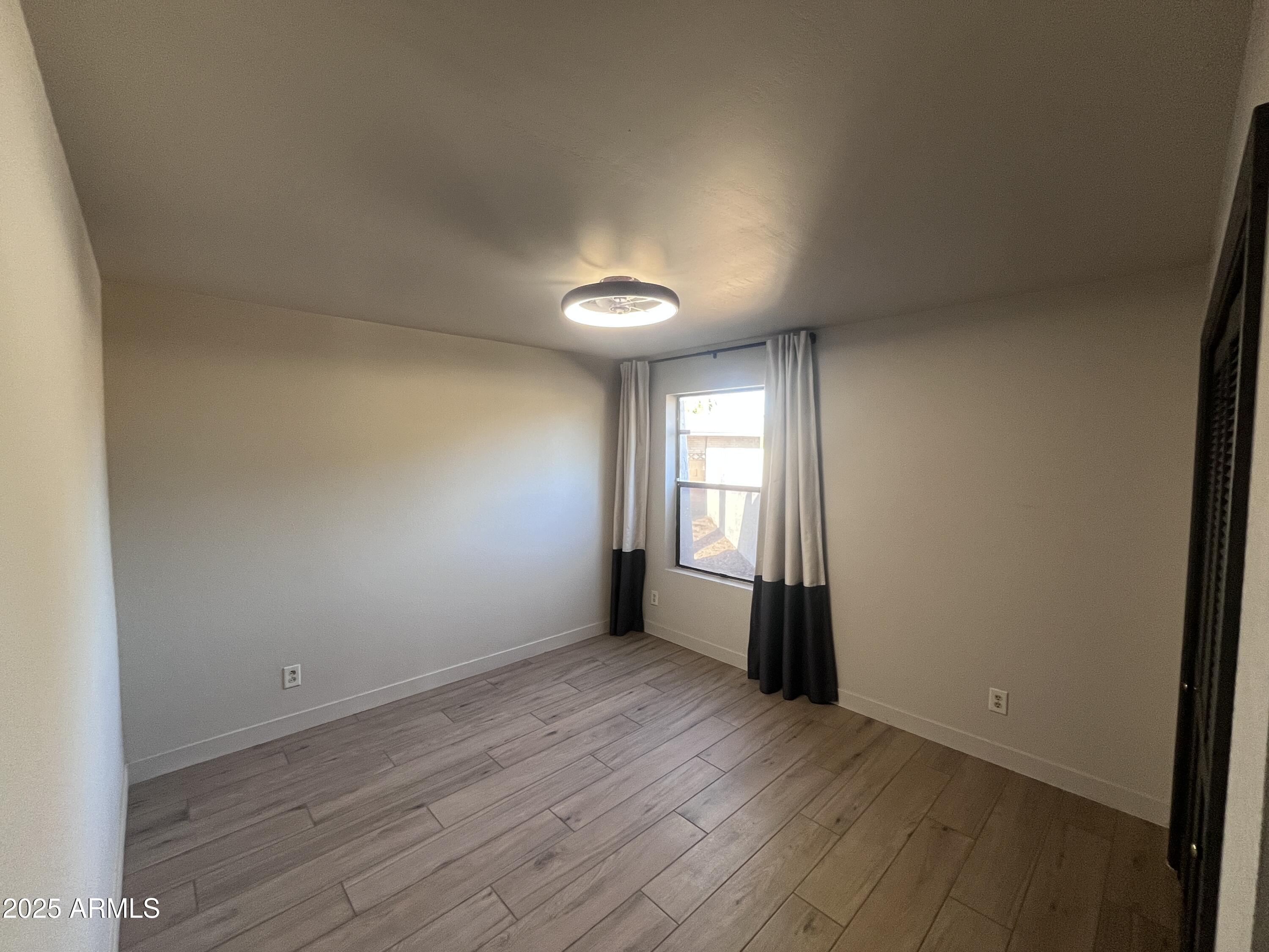 2129 East Huntington Drive Tempe, AZ 85282 - Photo 19 of 36 an empty room with wooden floor and windows