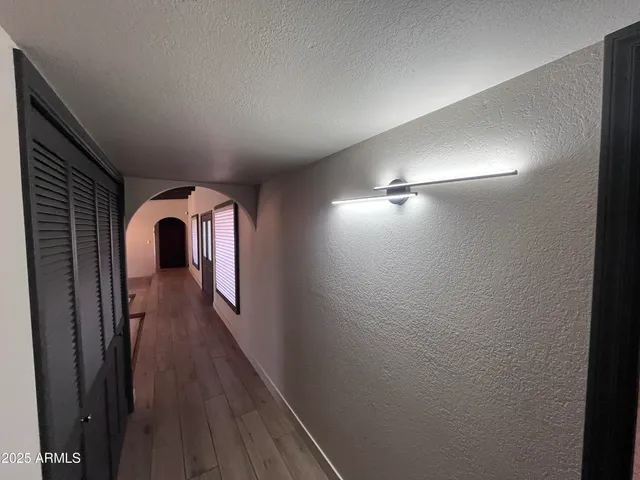 a view of a hallway with wooden floor and staircase