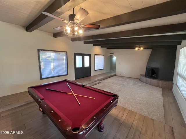 a room with pool table and windows