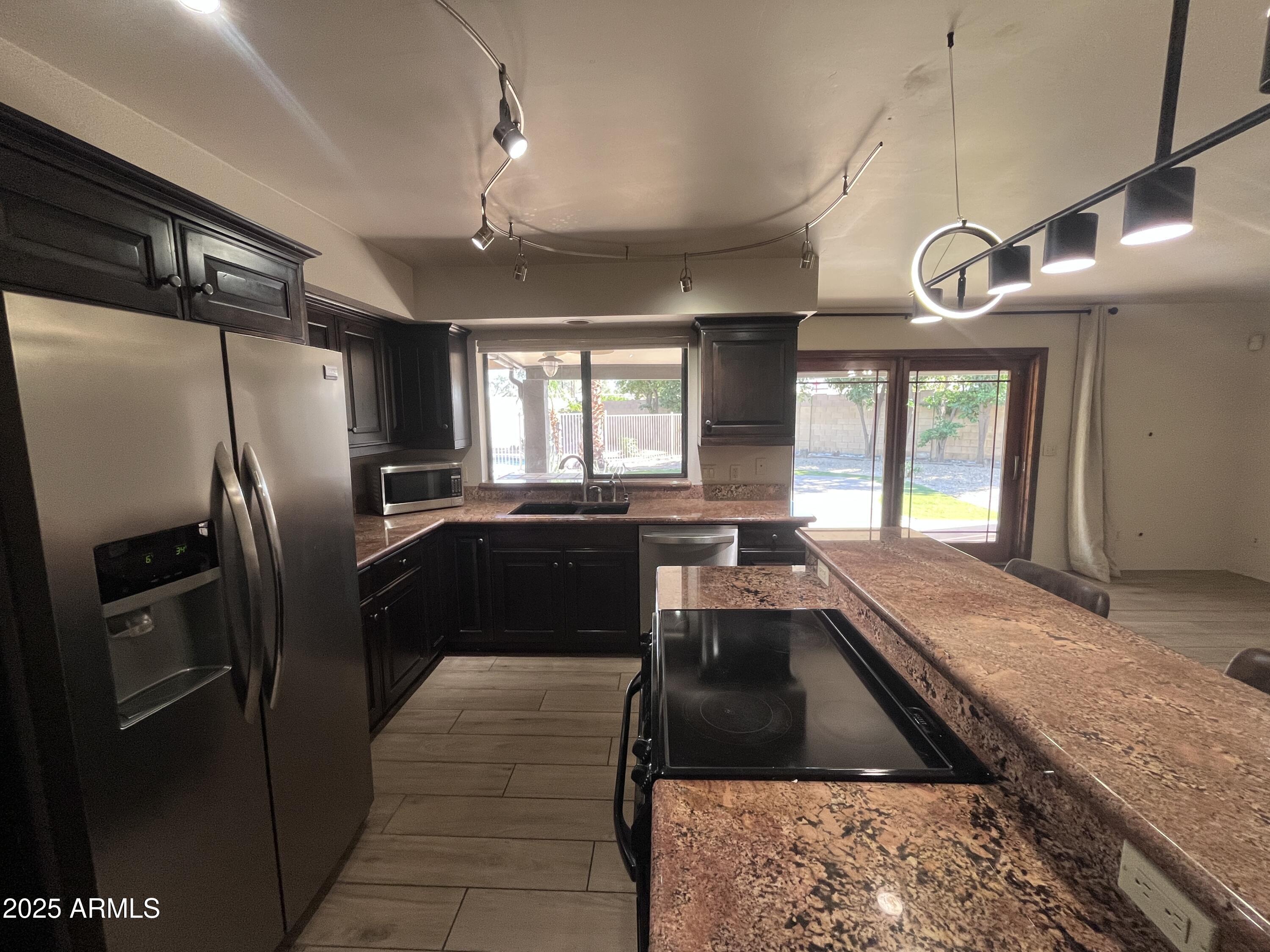 2129 East Huntington Drive Tempe, AZ 85282 - Photo 10 of 36 a kitchen with granite countertop stainless steel appliances a refrigerator a sink a stove and cabinets