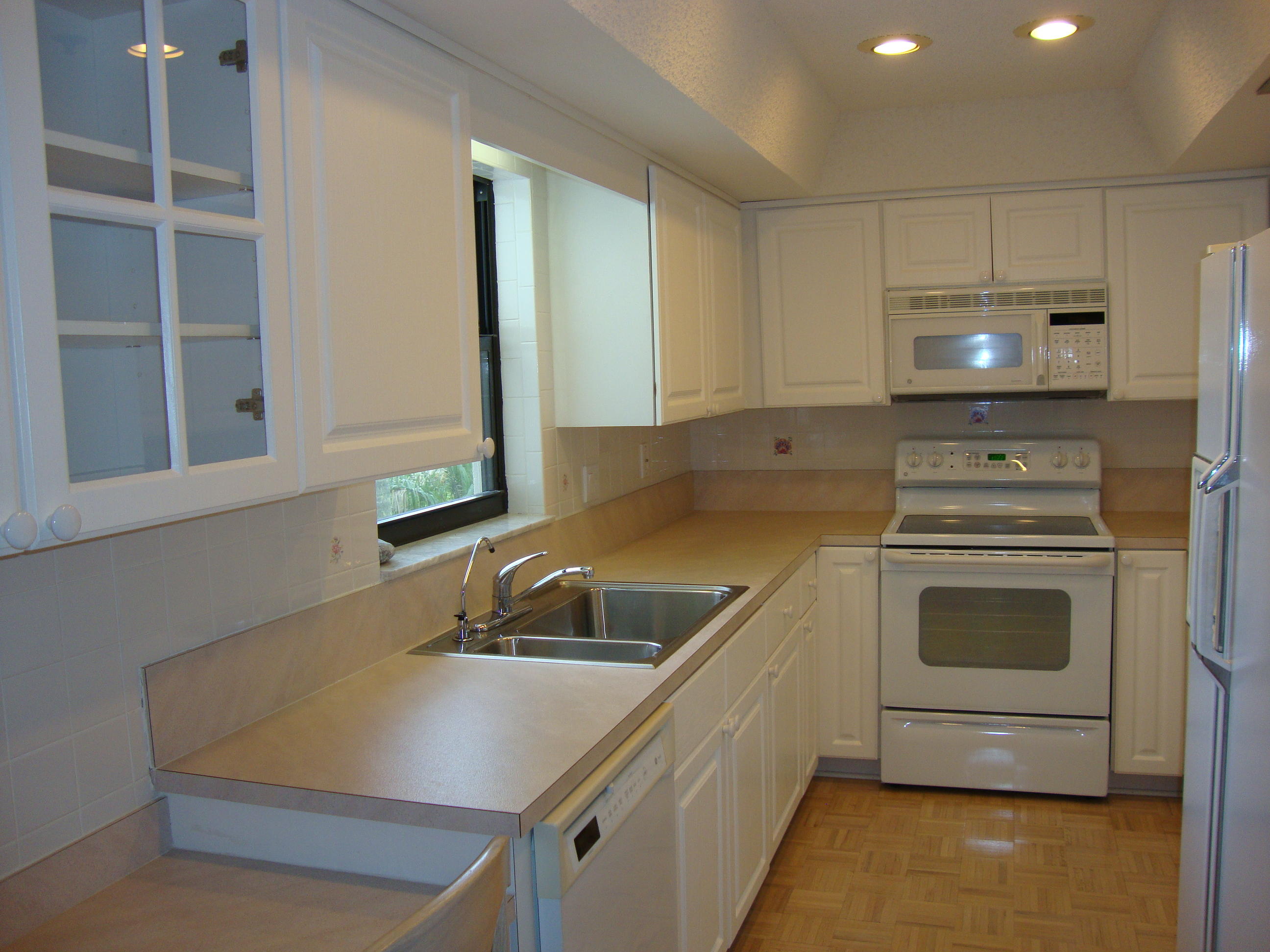 2679 South Ocean Boulevard, Unit 2B Boca Raton, FL 33432 - Photo 9 of 42 a kitchen with a sink a stove and cabinets