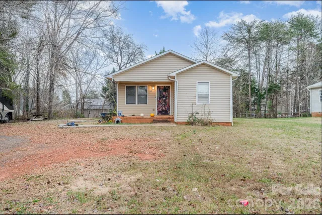 a view of a house with a yard covered with trees