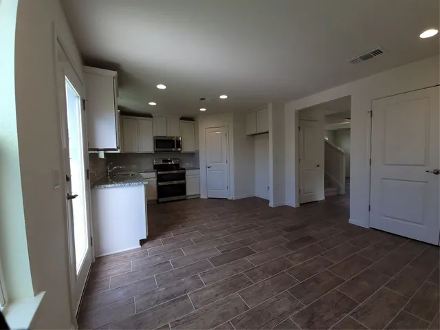 a view of kitchen with kitchen island granite countertop a stove and a refrigerator